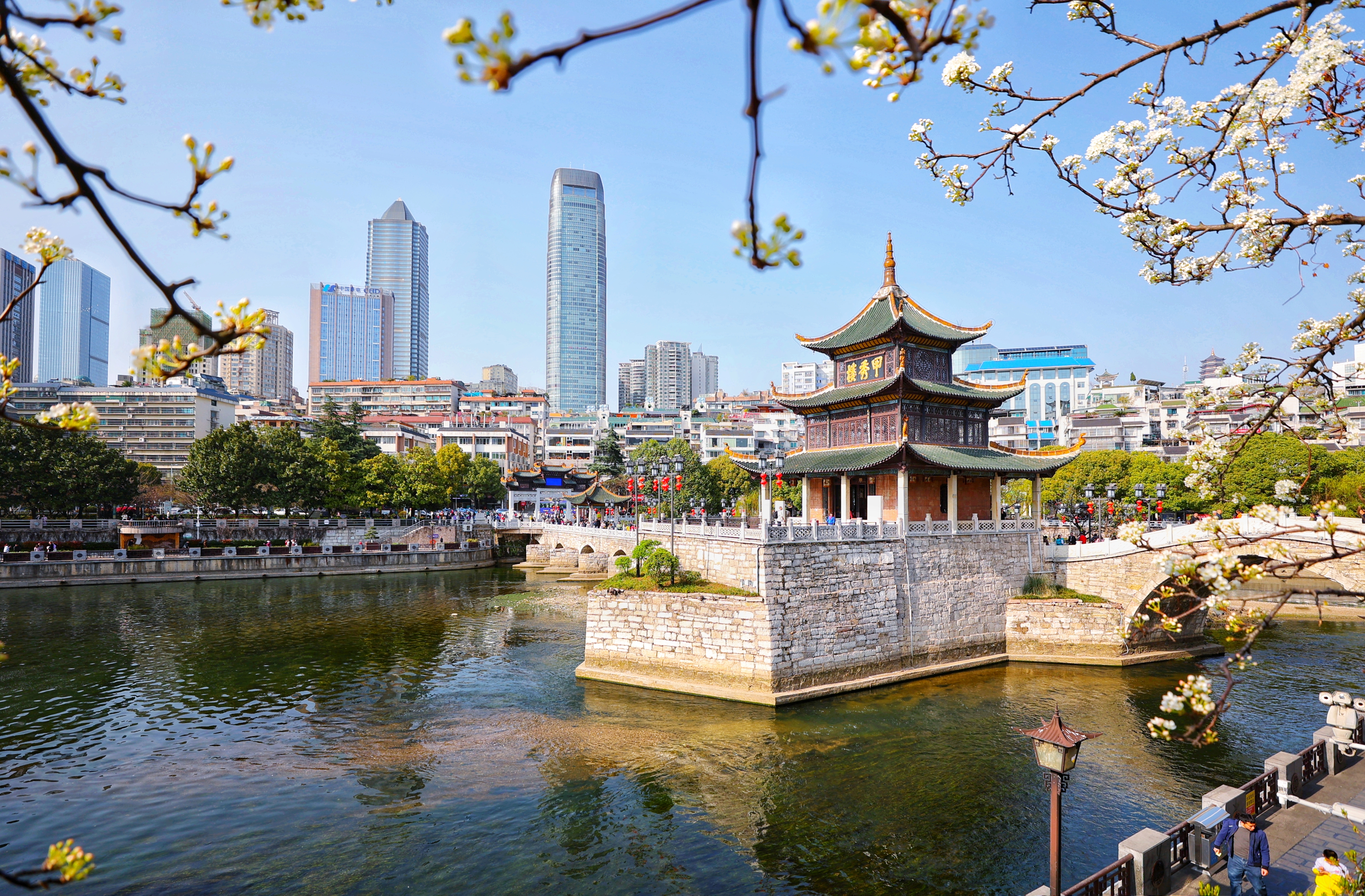 3月19日,游客在甲秀楼游玩赏景。 最近,有网友发现一处欣赏甲秀楼风光的全新角度:从位于箭道街一侧的南明河岸边茶馆看去,甲秀楼半掩于盛开的李花中,加之清澈见底的南明河水,洁白的岸边李花,悦耳的鸟鸣,空中自由飞翔的白鹭,使甲秀楼呈现出一种有别于常规视觉的魅力和美感来,令人更加赏心悦目,美不胜收,美妙的欣赏角度令不少游客纷纷前往打卡拍照。 (3)